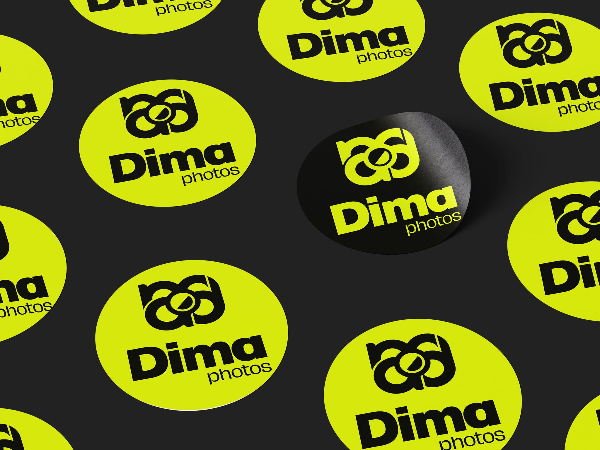 Adesivi tondi di Dima photos sparsi su un fondo nero: gialli fluo col logo nero, e uno nero col logo giallo.