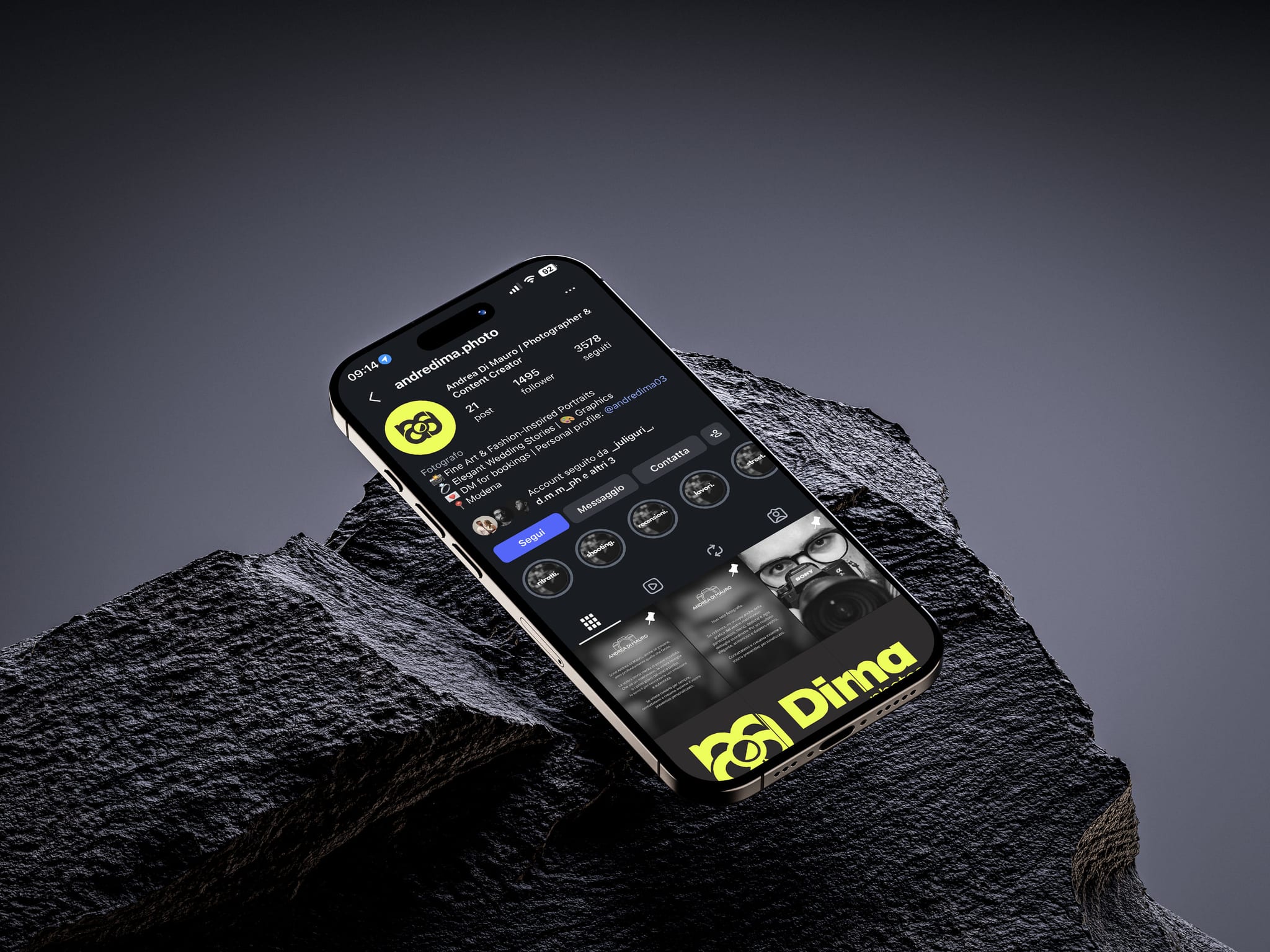 Il telefono appoggiato di sbieco su una roccia scura: sullo schermo il profilo Instagram di Dima photos, col monogramma nero su giallo fluo.