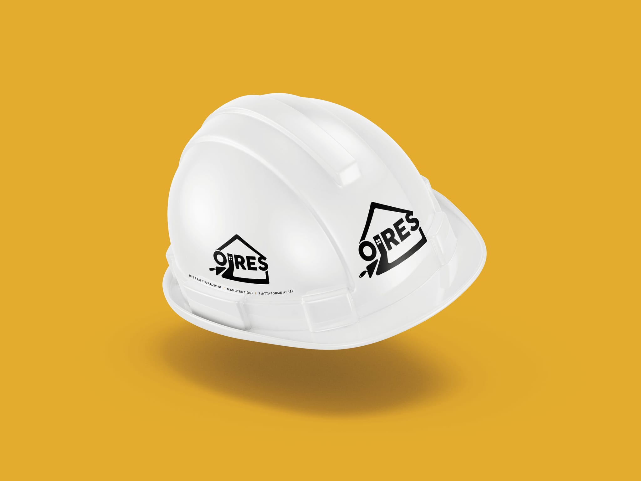 Un elmetto da cantiere bianco sospeso sopra la sua ombra, su un fondo giallo ocra: il marchio OIRES in nero sul davanti e sul fianco.