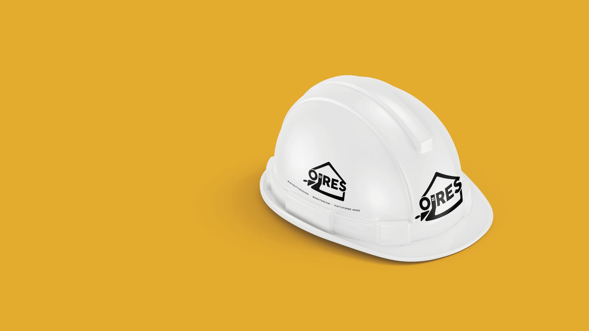 Un elmetto da cantiere bianco su un fondo giallo ocra, visto di tre quarti: il marchio OIRES in nero sul davanti, sopra la visiera, e sul fianco, con sotto la riga delle tre lavorazioni.
