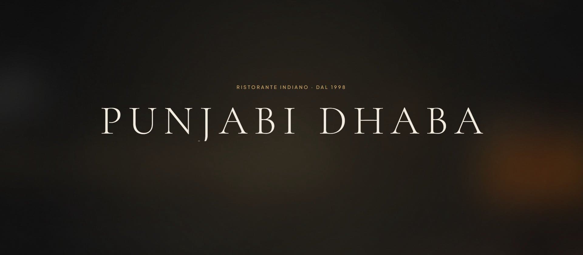 Il logotipo Punjabi Dhaba, ristorante indiano dal 1998, in chiaro su fondo scuro