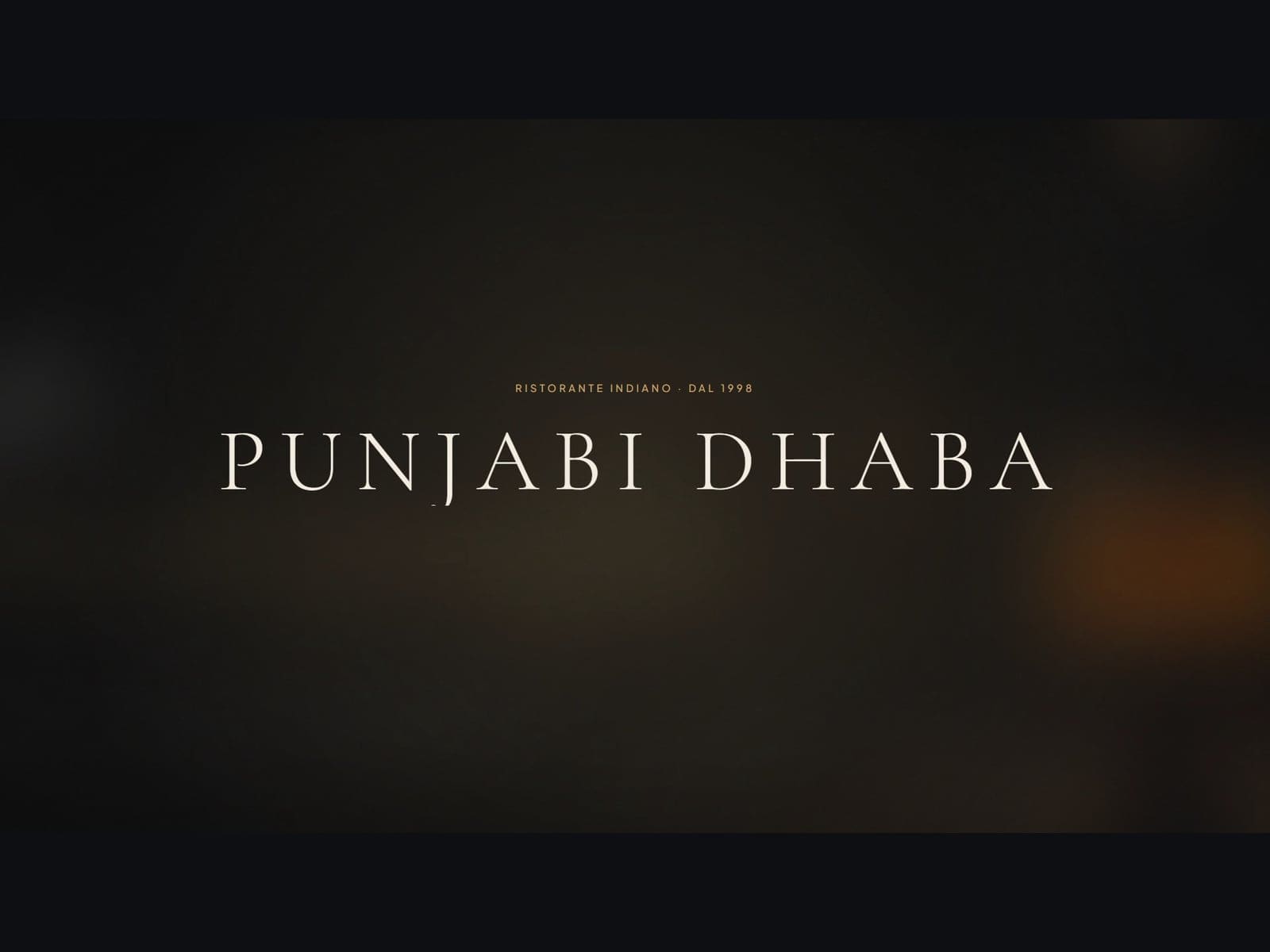Il logotipo Punjabi Dhaba, ristorante indiano dal 1998, in chiaro su fondo scuro